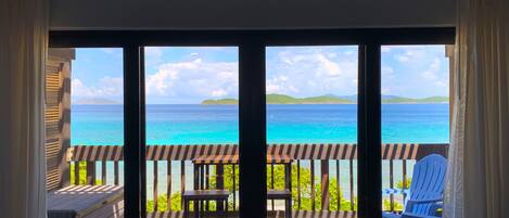 Un balcon avec vue sur l’océan, une chaise et une table.