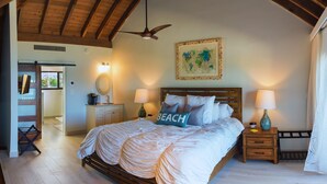 A bedroom with a wooden ceiling, a bed with white bedding, two bedside lamps, a world map on the wall, and a wooden floor.