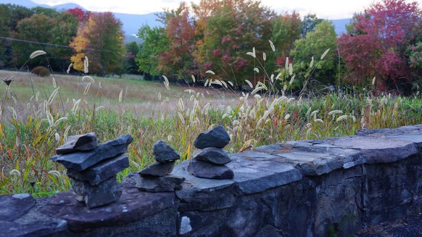 A stone wall with stacks of rocks in a natural setting with trees and grass. - Classic Cottage w/Beautiful Catskill View, on
5 peaceful acres. Weekly discount! (Stone Ridge)