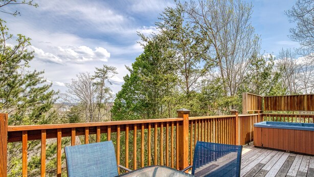 A wooden deck with a glass table and chairs, surrounded by trees and a hot tub. - Pigeon Forge Cottage w/ Hot Tub & City Lights, Near Dollywood Sleeps 7 (PIGEON FORGE, TN)