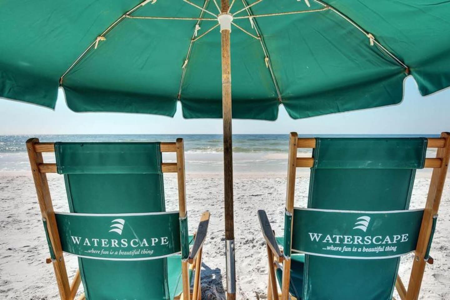 Two beach chairs with 'WATERSCAPE' branding and a green umbrella.