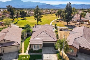 A residential area with houses featuring red-tiled roofs and a well-maintained lawn. - Sun-Kissed Oasis, Entertainers Dream on the Golf Course w/ Private Pool (Indio)