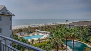 Um resort com piscina, praia e palmeiras.