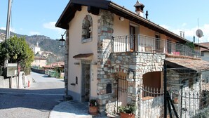 A stone building with a balcony, a door, and a small window. - CASA RITA - AP. N. 4 LAKE GARDA TREMOSINE (Vesio)
