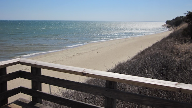 A beach with a wooden railing and a clear view of the ocean. - Private condo in Maushop. Steps to beach, ocean, Popponesset Inn and Marketplace (Mashpee)