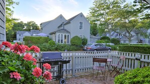A backyard with a grill, chairs, and a fence. - Private condo in Maushop. Steps to beach, ocean, Popponesset Inn and Marketplace (Mashpee)