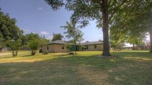 A residential house with a lawn, a large tree, and a small shed. - Close to a Vibrant and fun DownTown Rose District. 15 min from Tulsa. (Broken Arrow)
