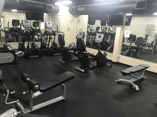A gym with various exercise equipment, including treadmills, stationary bikes, and weight machines. - Highly rated 3 br family condo in the heart of Destin- NOW booking for 2026! (Destin)