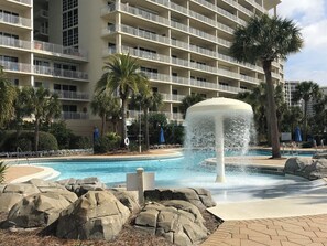 A hotel with a swimming pool, palm trees, and a fountain. - Highly rated 3 br family condo in the heart of Destin- NOW booking for 2026! (Destin)