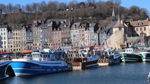 A harbor with boats docked, a church steeple, and a row of buildings along the water's edge. - Les Mouailleries on the ground floor 2 bedrooms 2 bathrooms (Honfleur)