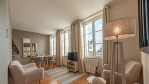 A modern living room with a TV, sofa, and lamp. - Les Mouailleries on the ground floor 2 bedrooms 2 bathrooms (Honfleur)