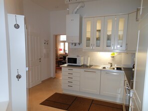 A modern kitchen with white cabinets, a microwave, and a sink. - 2bedroom Family Home, Air-Conditioning, Cable TV, Wifi, Metro (Vienna)