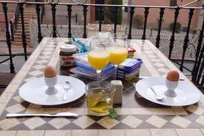 A table set with two plates, each with an egg, a glass of tea, and a glass of orange juice. There are also jars of Nutella and a box of margarine. - App,  2 bedroom ,2 terraces, Swimming pool + Parking, Wifi (Algorfa)