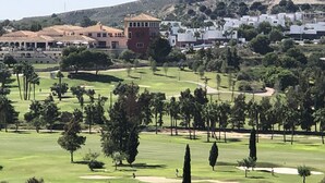 A golf course with a clubhouse, trees, and a hilly landscape in the background. - App,  2 bedroom ,2 terraces, Swimming pool + Parking, Wifi (Algorfa)