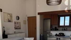 A living room with a sofa, a round coffee table, and a kitchen area in the background. - App,  2 bedroom ,2 terraces, Swimming pool + Parking, Wifi (Algorfa)