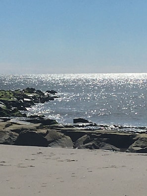 Ein Strand mit felsigem Ufer und ruhiger See.