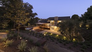 Uma casa moderna com um deck amplo, piscina e um jardim bem cuidado.