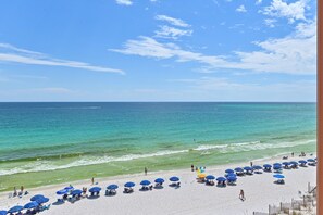 A beach with umbrellas and people.