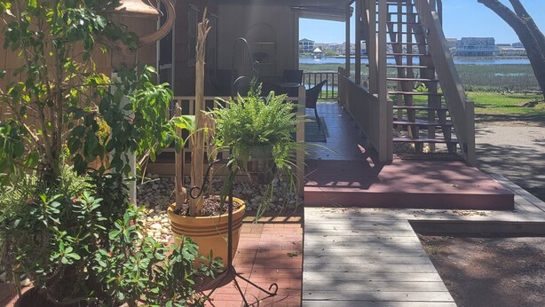 Une maison à deux étages dotée d’un balcon donnant sur un plan d’eau.