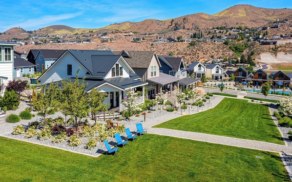 A residential area with houses, a swimming pool, and a well-maintained lawn.