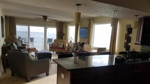 Een ruime woonkamer met een groot eiland, zitgedeeltes en uitzicht op de oceaan.