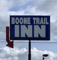 Señal para Boone Trail Inn con una flecha direccional.