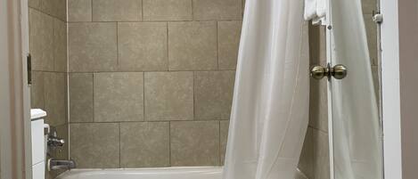 Une salle de bain équipée de toilettes, d’une baignoire et d’un rideau de douche.