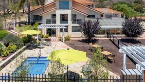Ein Haus mit Pool, Terrasse und Blick auf die Hügel.