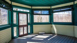 A room with a wooden floor, teal walls, and large windows. - Smuggler's Notch Resort by Resort Stay (Jeffersonville)