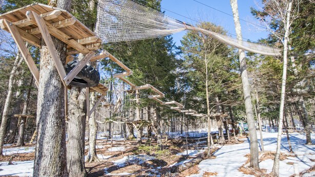 A wooden structure with a netted roof, surrounded by trees and snow-covered ground. - Smuggler's Notch Resort by Resort Stay (Jeffersonville)