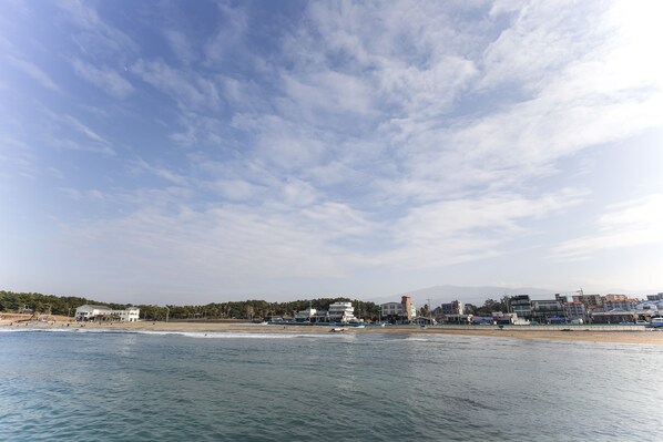 Vista costeira com edifícios, praia e oceano.