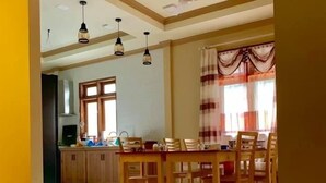 A spacious kitchen with wooden cabinets, a dining area with a table and chairs, and a ceiling fan.