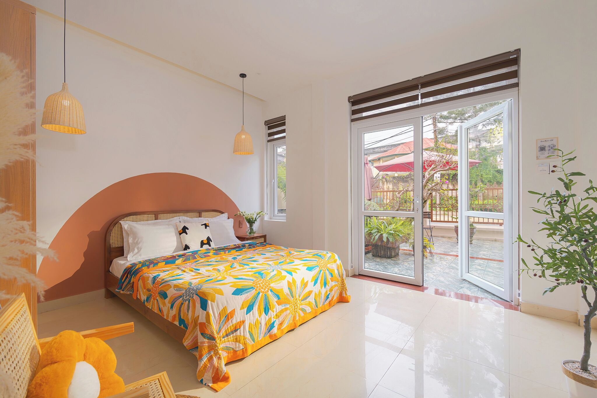 A bedroom with a bed, a window, and a potted plant.