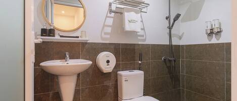 A bathroom with a sink, toilet, and shower.