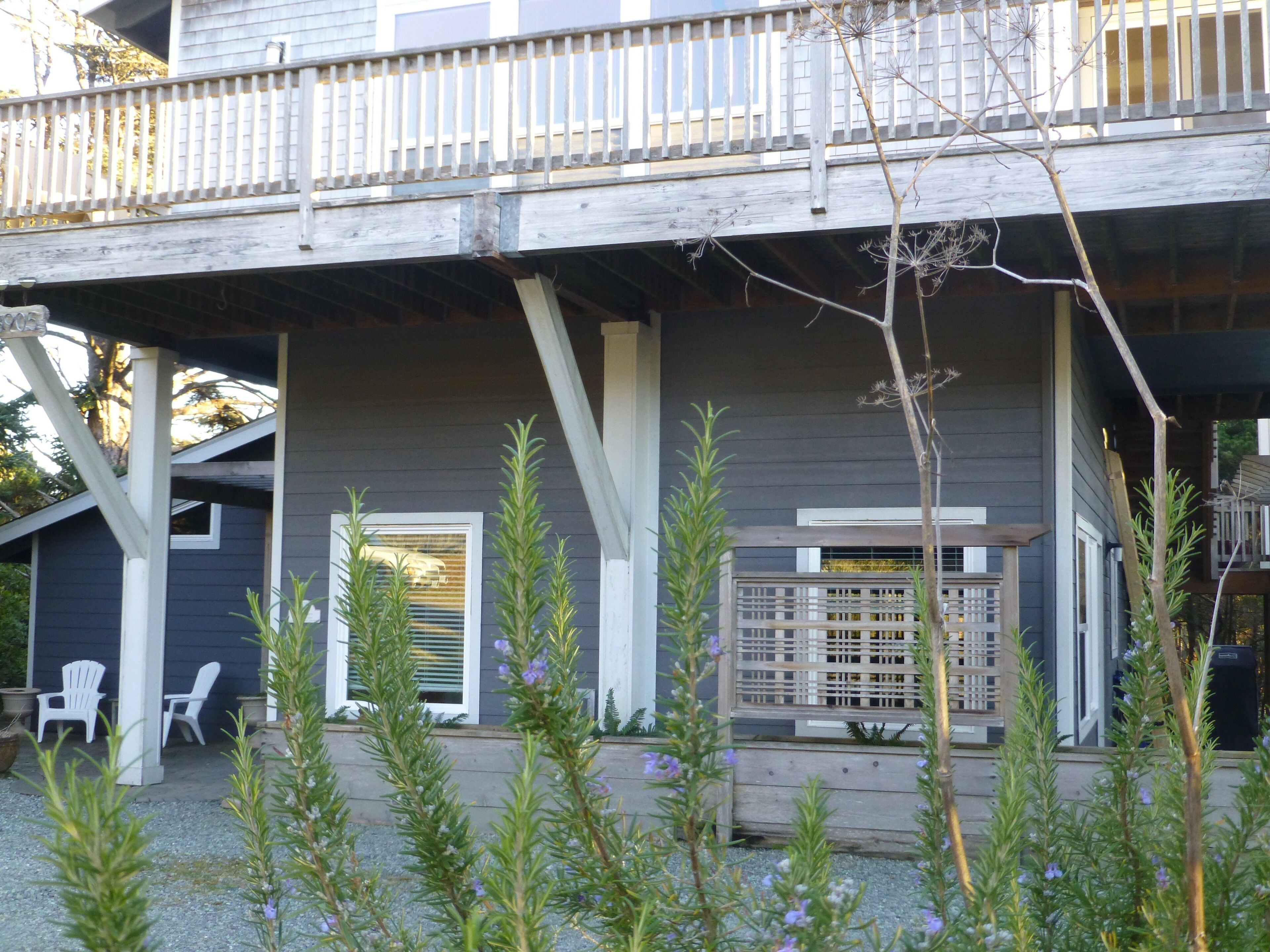 A house with a covered porch, outdoor seating, and a wooden deck.