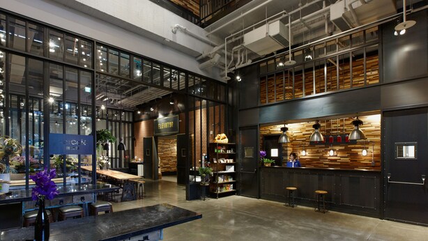 A spacious, modern interior with a high ceiling, exposed ductwork, and a mix of wooden and metal elements. - Just Sleep Sanchong (New Taipei City)