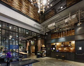 A spacious, modern interior with a high ceiling, exposed ductwork, and a mix of wooden and metal elements. - Just Sleep Sanchong (New Taipei City)