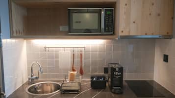 A kitchen with a sink, a microwave, a coffee maker, and a toaster.