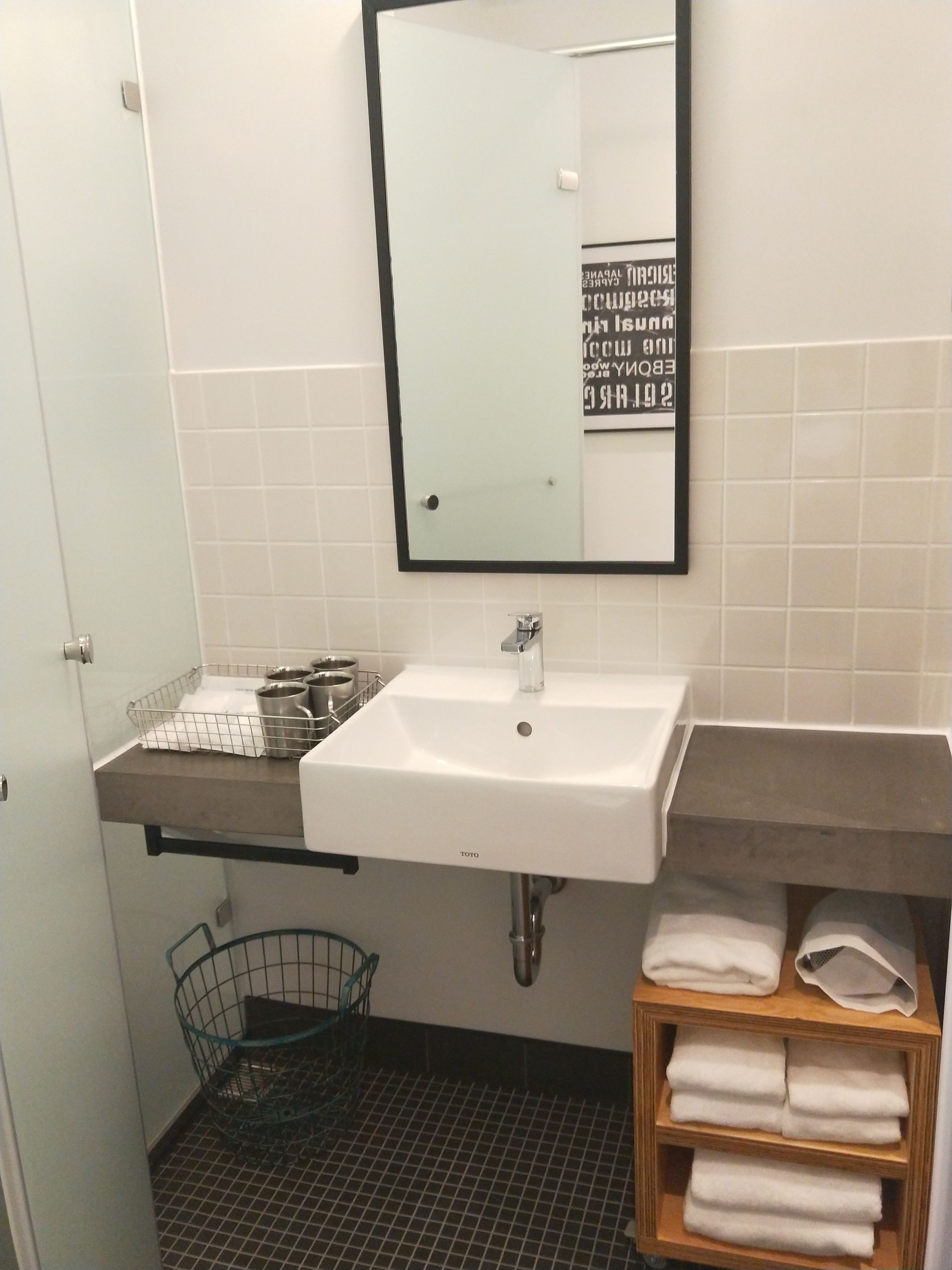 A bathroom with a white sink, a mirror, and a towel rack.