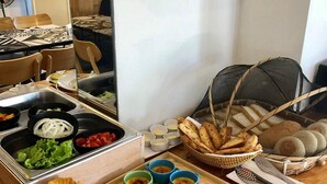 Ein reichhaltiges Buffet mit verschiedenen Speisen, darunter Croissants, Brot und mehrere Dipsaucen.