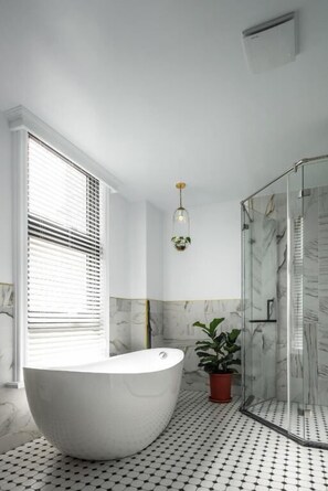Een aparte badkuip en douche, een diep bad, gratis toiletartikelen