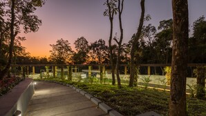 A pathway leading to a building with a modern design, surrounded by trees and greenery. - Siri Nature Roost (Chikkamagaluru)