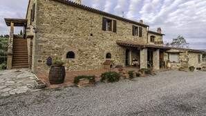 A stone building with a tiled roof, a wooden door, and a gravel driveway. -  Padronale house apartment Fontaccia (Montiano)