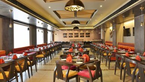 A spacious dining area with multiple tables and chairs, arranged in a U-shape. - TGB Express (Ahmedabad)