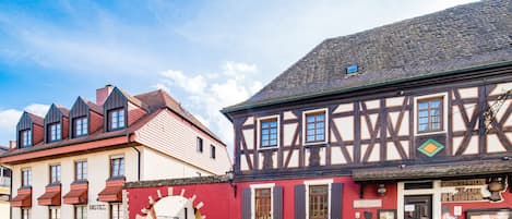 A traditional half-timbered building with a red facade and a sign indicating it is a hotel.