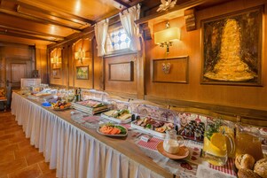 Uma mesa de buffet com diversos alimentos e um jarro de limonada.