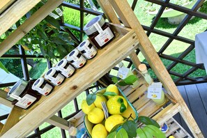 A wooden display rack with jars of honey and lemons. - Villa Soraya (Cava de' Tirreni)