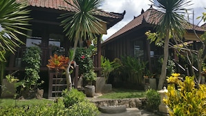 A traditional wooden building with a tiled roof, surrounded by lush greenery and tropical plants. - Perdana Lembongan (Lembongan Island)