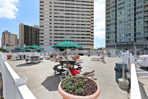 A rooftop patio with outdoor seating and a pool area.