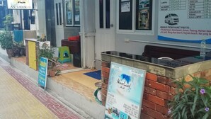 A building with a 'Dorm' sign, a bus schedule, and a 'Laundry' sign. - neverland hostel dorm in phi phi. (Koh Phi Phi)
